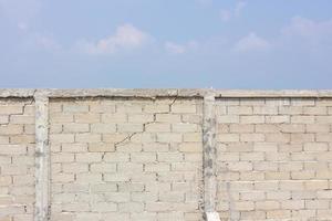 mur fissuré à l'arrière-plan des nuages et du ciel photo