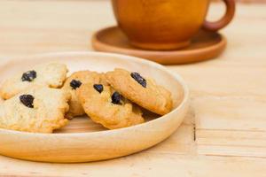 Biscuits aux raisins sur table en bois avec une tasse de café marron photo