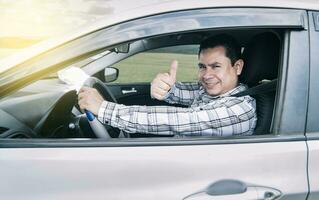 portrait de une homme montrant les pouces en haut tandis que conduite, homme dans le sien voiture donnant une les pouces en haut, content homme dans le sien voiture donnant une les pouces en haut photo