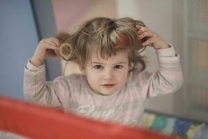 petite fille avec une coiffure étrange et des bigoudis photo