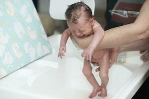 bébé nouveau-né prenant son premier bain photo