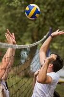 groupe de jeunes amis jouant au beach-volley photo