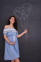 portrait de femme enceinte devant un tableau noir photo