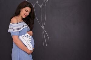 portrait de femme enceinte devant un tableau noir photo