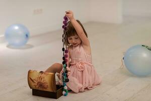 petite fille s'amusant en jouant avec les bijoux de sa mère photo