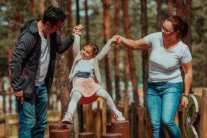 famille amusement dans le parc. content famille dépenses temps dans parc et en jouant avec leur fille photo