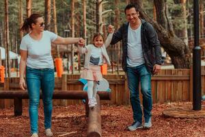 famille amusement dans le parc. content famille dépenses temps dans parc et en jouant avec leur fille photo