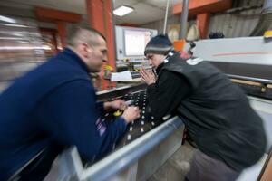 menuisiers calculant et programmant une machine à bois cnc photo