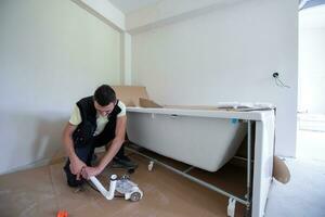 plombier professionnel travaillant dans une salle de bain photo