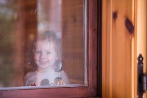 petite fille mignonne jouant près de la fenêtre photo