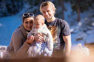 jeune famille heureuse avec petit enfant profitant de la journée d'hiver photo