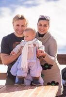 jeune famille heureuse avec petit enfant profitant de la journée d'hiver photo