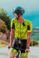 plein longueur portrait de un actif triathlète dans tenue de sport et avec une protecteur casque équitation une vélo. sélectif concentrer photo