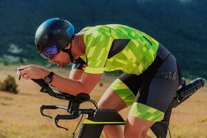 proche en haut photo de un actif triathlète dans tenue de sport et avec une protecteur casque équitation une vélo. sélectif concentrer