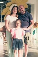 portrait de une content famille. photo de Parents avec les enfants dans une moderne préscolaire salle de cours