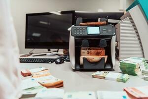 trié billets de banque mis sur le table après il est dénombré sur le électronique argent compte machine photo