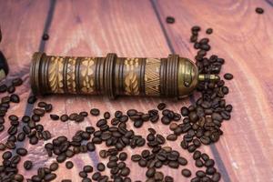 grains de café torréfiés et un moulin à café vitage photo