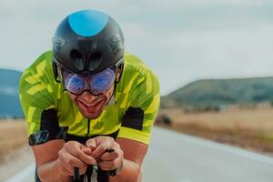 proche en haut photo de un actif triathlète dans tenue de sport et avec une protecteur casque équitation une vélo. sélectif concentrer