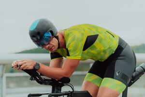 proche en haut photo de un actif triathlète dans tenue de sport et avec une protecteur casque équitation une vélo. sélectif concentrer