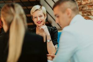 content hommes d'affaires souriant gaiement pendant une réunion dans une café magasin. groupe de réussi affaires professionnels travail comme une équipe dans une multiculturel lieu de travail. photo