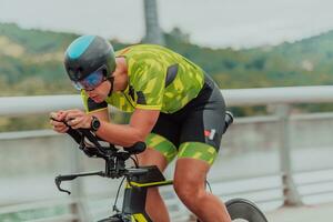 plein longueur portrait de un actif triathlète dans tenue de sport et avec une protecteur casque équitation une vélo. sélectif concentrer photo