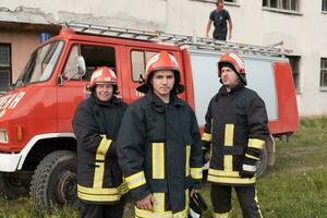 groupe de Feu combattants permanent sur de soi après une bien terminé porter secours opération. pompiers prêt pour urgence service. photo