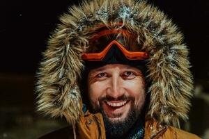 tête coup de une homme dans une du froid neigeux zone portant une épais marron hiver veste, neige des lunettes de protection et gants sur une du froid scandinave nuit. la vie dans le du froid Régions de le pays. photo