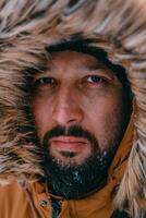 photo du visage photo de une homme dans une du froid neigeux zone portant une épais marron hiver veste et gants. la vie dans du froid Régions de le pays.