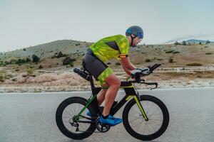 plein longueur portrait de un actif triathlète dans tenue de sport et avec une protecteur casque équitation une vélo. sélectif concentrer photo