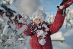 fille jetant de la neige fraîche à la belle journée d'hiver ensoleillée photo