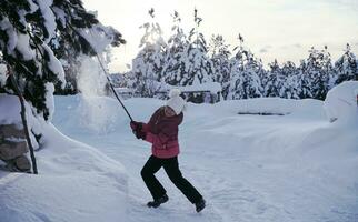 fille jetant de la neige fraîche à la belle journée d'hiver ensoleillée photo