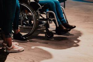 proche en haut photo de une femme avec une invalidité séance dans une fauteuil roulant dans le Bureau