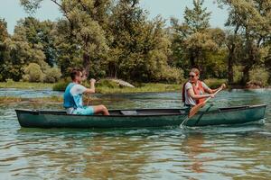 couple aventureux explorateur copains sont canoë dans une sauvage rivière entouré par le magnifique la nature photo