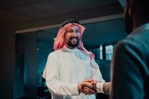 un personnes âgées arabe homme tremblement mains avec une homme d'affaire et fin une affaires réunion avec réussi affaires offres photo