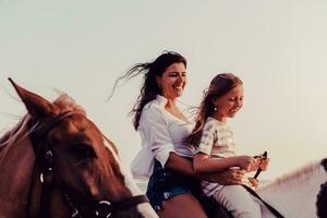 mère et fille aiment monter à cheval ensemble au bord de la mer. mise au point sélective photo