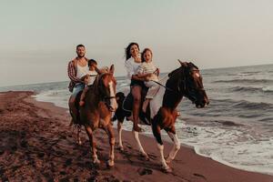 la famille passe du temps avec ses enfants tout en faisant de l'équitation ensemble sur une plage de sable. mise au point sélective photo