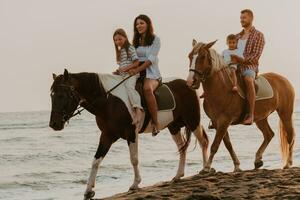 la famille passe du temps avec ses enfants tout en faisant de l'équitation ensemble sur une plage de sable. mise au point sélective photo