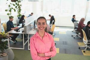 portrait de Jeune souriant affaires femme dans Créatif ouvert espace cotravail Commencez bureau. réussi femme d'affaires dans moderne bureau. équipe de collègues de travail travail dans Contexte. photo