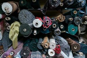 intérieur de un industriel entrepôt avec en tissu Rouleaux échantillons. petit affaires textile coloré entrepôt. photo