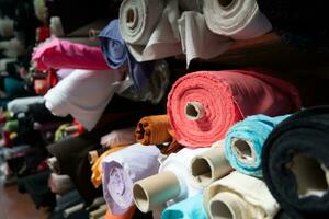 intérieur de un industriel entrepôt avec en tissu Rouleaux échantillons. petit affaires textile coloré entrepôt. photo