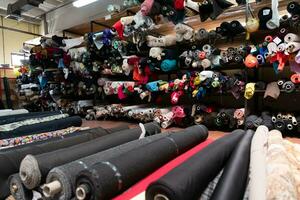 intérieur de un industriel entrepôt avec en tissu Rouleaux échantillons. petit affaires textile coloré entrepôt. photo