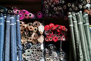 intérieur de un industriel entrepôt avec en tissu Rouleaux échantillons. petit affaires textile coloré entrepôt. photo