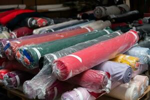 intérieur de un industriel entrepôt avec en tissu Rouleaux échantillons. petit affaires textile coloré entrepôt. photo