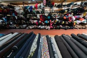 intérieur de un industriel entrepôt avec en tissu Rouleaux échantillons. petit affaires textile coloré entrepôt. photo