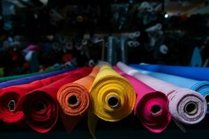 intérieur de un industriel entrepôt avec en tissu Rouleaux échantillons. petit affaires textile coloré entrepôt. photo