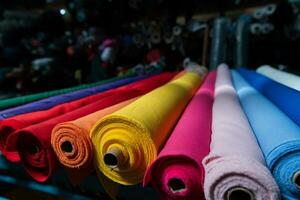 intérieur de un industriel entrepôt avec en tissu Rouleaux échantillons. petit affaires textile coloré entrepôt. photo