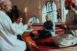 une groupe de les musulmans en train de lire le saint livre de le coran dans une moderne mosquée pendant le musulman vacances de Ramadan photo