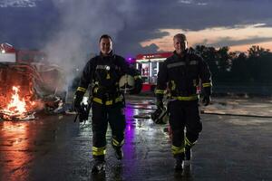 courageux sapeurs pompiers équipe en marchant à le caméra. dans Contexte ambulanciers et pompiers porter secours équipe bats toi Feu dans voiture accident, Assurance et enregistrer les peuples vies concept. photo