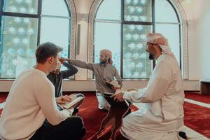 une groupe de les musulmans en train de lire le saint livre de le coran dans une moderne mosquée pendant le musulman vacances de Ramadan photo