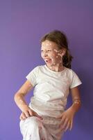 portrait de une peu école fille avec varicelle, antiseptique crème appliqué à visage et corps .coloré Contexte. photo